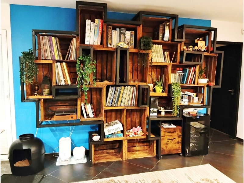 Création sur mesure d'une grande bibliothèque style industriel et rustique, fabriquée à partir de cagettes de pommes recyclées et de sapin noir.