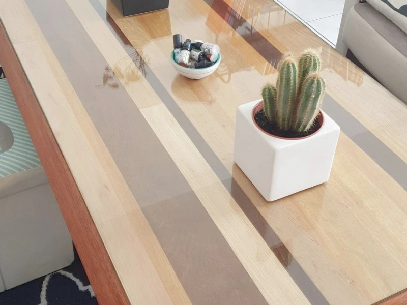 Table basse artisanale avec un plateau réversible multi-essences et des pieds en rondin de châtaignier.